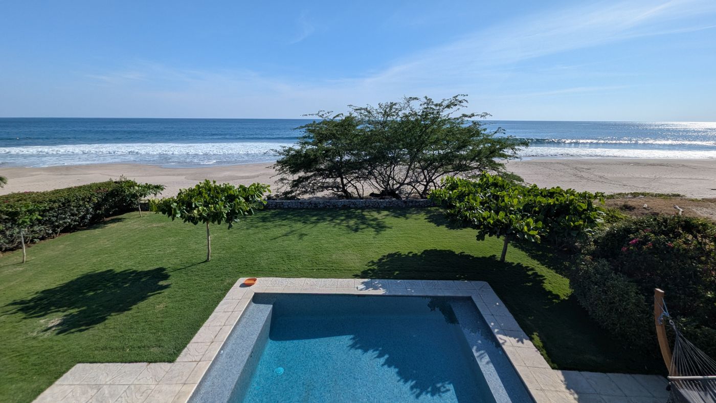Balcony view over pool garden beach and surf break